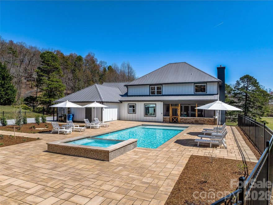 Completely transformed modern farmhouse on 5.5 acres w/ mountain views! This 4BR/3.5BA home features premium designer finishes, top-tier upgrades & $100K+ in smart tech: whole-home audio, Lutron lighting, power shades, security cameras on 4 sides & more. Interior highlights include engineered hardwoods, shiplap, coffered ceilings, soundproof office & living room each w/ gas fireplace plus gourmet kitchen w/ 10' quartzite island, workstation sink & Thermador appliances, including dual-fuel range w/ warming drawer, convection oven. Primary suite has raised ceiling, brick accent wall, & spa-like bath w/ chromotherapy clawfoot tub, heated tile floor, walk-in closet. Backyard oasis touts 18’x38’ heated saltwater gunite pool w/ hot tub, swim jet, Baja shelf, auto cover, smart lighting. Screened porch w/ outdoor TV, EV-ready garage, RV pad w/ 50-amp plug, fully conditioned crawlspace. Turnkey luxury experience convenient to Asheville & Hendersonville amenities. Only 9 minutes to the Asheville airport.