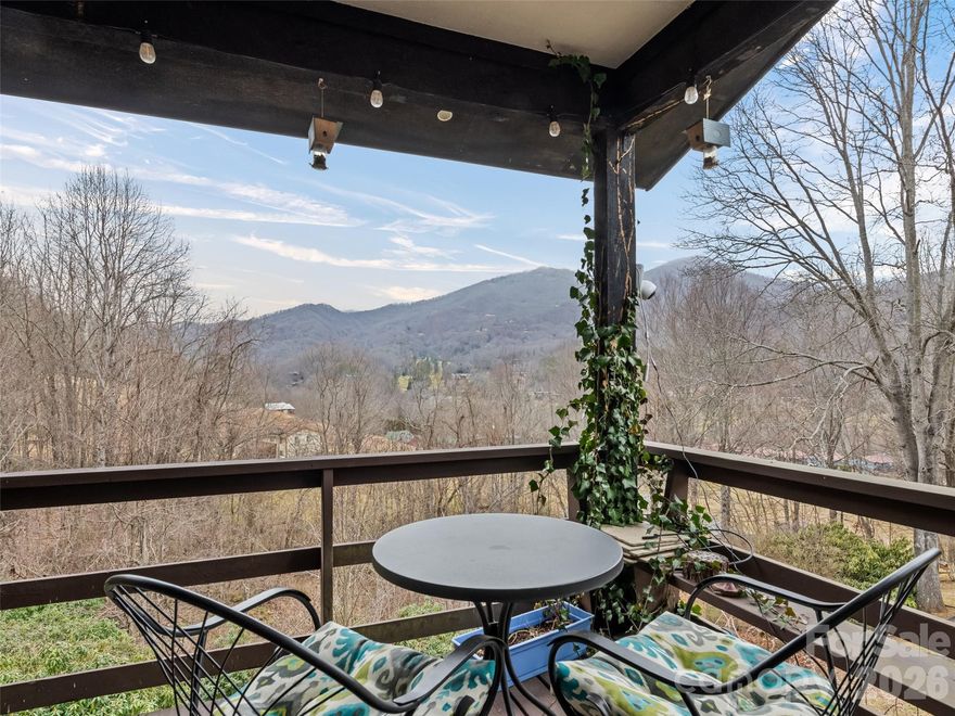 Enjoy sweeping, long-range westerly views and unforgettable Maggie Valley sunsets from this thoughtfully remodeled mountain home. INCOME producing rental history for the lower-level apartment (2025: $5.4k | 2024: $7.6k | 2023: $10.3k). Recent updates include a custom kitchen, fresh interior paint, and new flooring. The open-concept living and dining area features a wood-burning fireplace and a convenient pass-through to the kitchen, creating a warm and inviting flow for everyday living or entertaining. Step outside to the expansive 30' × 10' covered deck and take in the peaceful scenery. The kitchen is beautifully appointed with a farm sink, new appliances, butcher-block countertops, new cabinetry, and modern lighting. The second bedroom is currently used as a studio/office, offering flexible living options. The primary bedroom includes an ensuite bath and direct access to the deck. A main-level laundry room provides easy one-level living. The lower level offers a newly remodeled living area/bedroom/rental studio with a full bath—ideal for guests or short- or long-term rental use—and features its own large covered deck plus a storage room. The sunny yard and gardens are frequented by elk and other wildlife, and a creek runs along the bottom of the property. Hot tub included, an 8'×8' storage shed, Spectrum high-speed internet, no HOA, and no city taxes. NEW WHOLE HOUSE GENERATOR and plug receptacle, newly REWIRED ELECTRIC PANEL. Please note the home shares a common wall (kitchen and living area) with the neighboring Unit #A. Rental Apt furniture included... main house furniture negotiable.