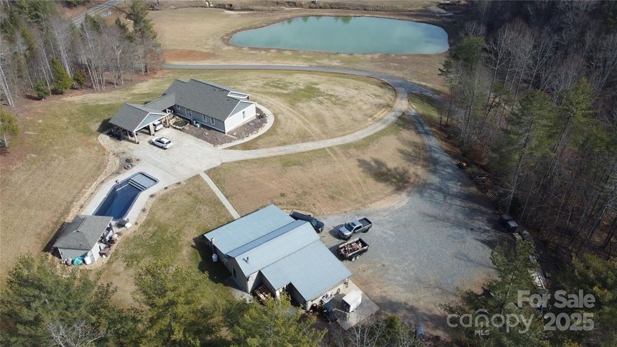 Nestled on 3.79 acres in the Foothills of Western NC, this stunning 3BR 3BA Ranch Style home with finished basement offers the perfect blend of style, comfort & tranquility looking over a 1-acre pond & streams.  The main level offers a kitchen with island & breakfast bar, dining area, cozy living room with gas logs, laundry area and pantry, 3 bedrooms & 2 full baths-Primary bedroom has walk-in closet with shoe rack & primary full bath with dual showers, 1 of the 3 bedrooms is set up as an office.  The finished basement features a 2nd laundry hook-up, den, full bath, 3 finished rooms used as additional bedrooms & large unfinished storage room. Enjoy your private oasis, perfect for hosting gatherings at the gorgeous remodeled in-ground pool with tanning ledge & new liner or spend your evenings relaxing on the front/back porch with beautiful & serene views. This home also features a 2,192 sq ft 5-bay workshop with a full kitchen &  bath. Make this your forever dream home.  Agent is Owner.