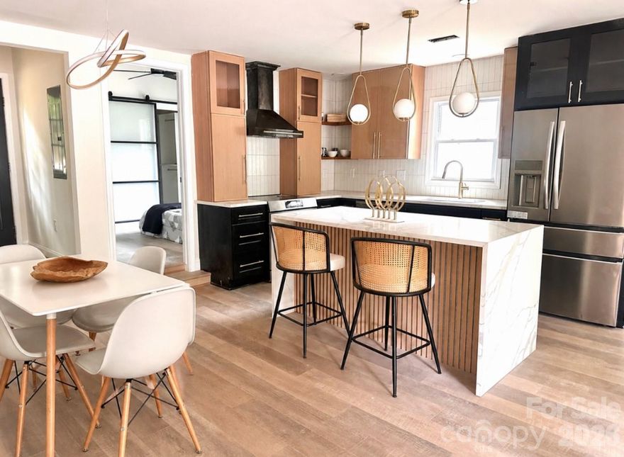 Welcome to this beautifully-reimagined home in the heart of Charlotte, thoughtfully designed with eye-catching touches throughout. Camp North End, Uptown, and major highways are just minutes away! 

 From the moment you step inside, you’ll appreciate the attention to detail, stylish finishes, and functional split-bedroom floorplan that offers both comfort and privacy.

The stunning updated kitchen serves as the centerpiece of the home, featuring a waterfall island, brand-new quartz countertops, sleek stainless steel appliances, designer lighting, appliance housing, and gorgeous new white oak-look flooring that flows seamlessly throughout the living spaces.

Retreat to the oversized primary suite featuring a spa-inspired walk-in shower, walk-in closet, and luxurious designer touches. Or soak the day's stress away in the beautiful standalone tub. The spacious secondary bedrooms provide flexibility for family, guests, or a home office/man cave setup. And the large laundry room/mudroom delivers functionality for modern living.  

Major system upgrades give peace of mind for years to come, including new windows, a new roof/gutters, and new HVAC system.

Step outside to enjoy the deck and the large fenced back yard shaded by mature trees — the perfect setting for entertaining, pets, gardening, or simply relaxing in your own private outdoor retreat.

This move-in ready, fully-permitted gem combines modern updates, timeless style, and everyday functionality in one exceptional Charlotte property. Welcome home!