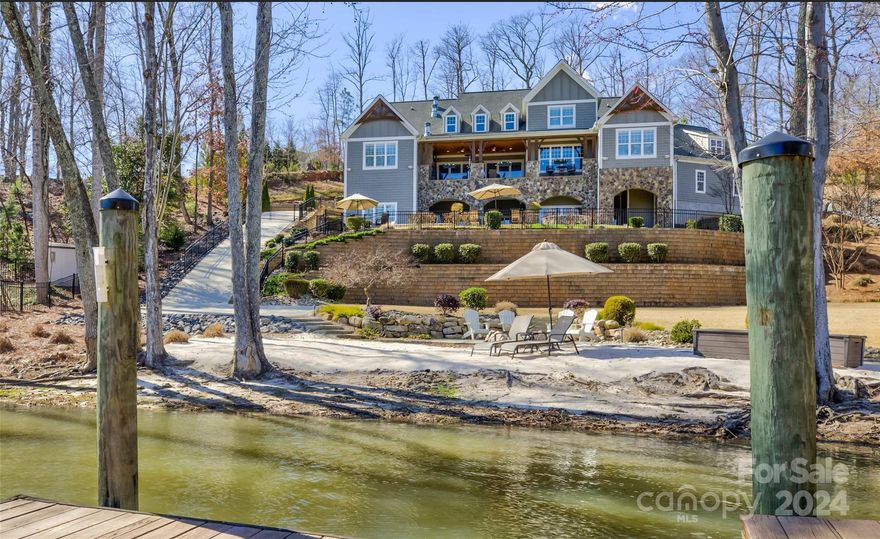 An extraordinary lakefront estate on 2.29 acres, a private sandy beach & breathtaking sun & moon rise. Boat dock & lift, two jetski docks & swim platform. Dream home, vacation, and or multi-generational home with over 9,000 Sq Ft and luxurious details throughout. 2 primary suites, two full kitchens, a bunkroom, a safe room, & over 11ft ceiling on the lower level, and an elevator servicing all floors. Exposed beams highlight the vaulted ceilings. The natural stone fireplace in the great room is echoed on the covered balcony patio. The folding glass wall opens for gracious indoor-outdoor living—pool & Hot tub w/ travertine surround. The gourmet kitchen has a subzero fridge, an enormous island, and a gas range with a double oven. The main primary suite features vaulted ceilings, a walk-in shower, travertine floors, and a stunning copper clawfoot tub. All 2nd-floor bedrooms have private baths. Laundry on main & 2nd upstairs. Bonus rm w/movie room.5 min drive from The Palisades Country Club