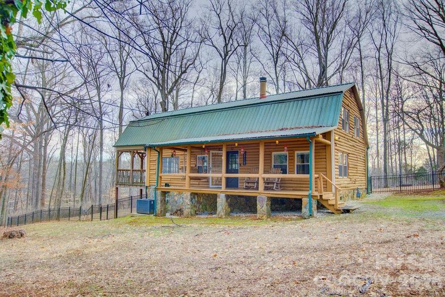 As you pull into the driveway, the noise of the day melts away and you’re instantly transported to your own Steele Creek mountain retreat. Surrounded by wooded views and rustic charm, this two-story log cabin feels like a peaceful escape—yet when you head back out, you’re just minutes from premium outlets, restaurants, the airport, Hwy 77, and I-485. Truly the best of both worlds.
Inside, the open-concept layout is warm and inviting. The kitchen features a large island, stainless steel appliances, gas cooktop, beverage fridge, and beautiful views of the lot—perfect for everyday living. The primary bedroom is conveniently located on the main floor with a full bath, while upstairs offers two additional bedrooms and another full bathroom. Relax on the covered front porch swing or rocking chairs, or entertain on the side covered porch with vaulted ceilings. A powered detached building in the back offers great potential for storage or an ADU with a little TLC. Sold “as is,” this charming cabin blends peaceful retreat living with unbeatable city convenience.