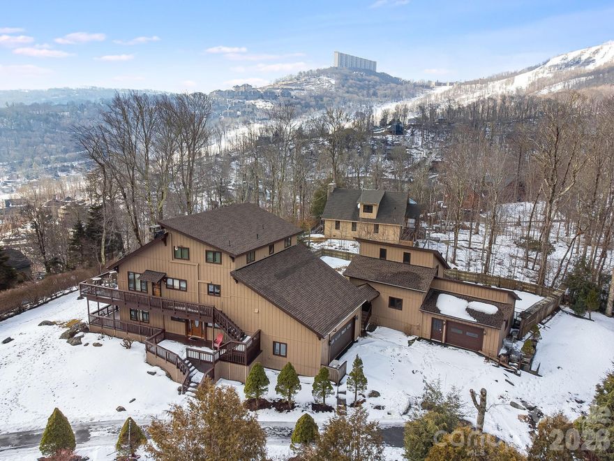 Experience the pinnacle of High Country living in this expansive 4-bedroom, 3.5-bathroom mountain retreat, perfectly situated on a private, level lot with breathtaking views of Sugar Mountain Resort and the surrounding peaks. Spanning over 4,400+sq.ft., the light-filled interior is anchored by soaring vaulted beamed ceilings and a thoughtful open-concept design that provides dedicated bedrooms and full baths on every level for maximum privacy. Entertain with ease by one of two majestic stone gas fireplaces or unwind on the massive double-level decks featuring miles of long-range mountain views. The lower level boasts a large entry foyer and versatile multi-purpose area with a full bar—ideal for a game room or den— and includes 1 Bedroom/1 Bathroom and separate laundry area. The second level (featuring its own exterior entrance) offers a grand family and dining area with a spacious eat-in kitchen and includes 1 Bedroom/1 Bathroom and a 1/2 bath. The third level provides 2 additional spacious bedrooms with 1 full bath. Meticulously maintained for total peace of mind, recent improvements include a new roof (2023), fresh exterior paint (2022), a new water heater (2021), and updated electrical and fixtures (2019), full list provided in attachments. Beyond the main residence, a detached building with an attached garage and greenhouse offers a "blank canvas" for a studio, workshop, or additional storage. Located just minutes from Sugar Mountain’s premier skiing, golf, and tennis, and a short drive to the charming towns of Banner Elk, Blowing Rock, and Boone. Whether you're seeking a serene primary residence or a high-yield short-term rental investment, this property delivers the ultimate Blue Ridge experience. Schedule your showing today.