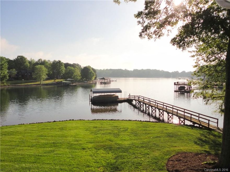 Grand views! Gracious Lake Living at an affordable price! Impeccably maintained home on gently sloping waterfront lot. 128 feet of shore line with deep water at covered boat slip. Many updated features including hickory wood floors, screened porch, tile shower w/dual sink & granite vanity in master, office & entertainment cabinets. Seven zone irrigation system. Plenty of charm and comfort here. Must see!! Energy efficient windows and new plumbing PEK throughout. Home warranty included.