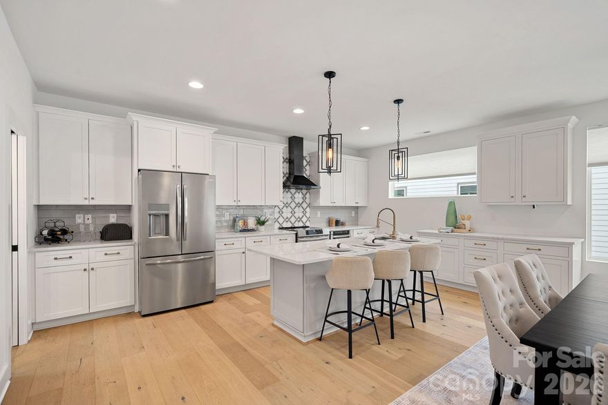 Set in the heart of Wesley Heights and just minutes from Uptown, this modern townhome delivers true city living with space to breathe. Walk to dining, breweries, the greenway, and trolley, then come home to your own private rooftop retreat with more than 800 square feet of outdoor living and skyline views. Inside, the open layout is bright and inviting, built for both everyday living and effortless entertaining. The kitchen anchors the main level with a generous island, stainless steel appliances, and added custom cabinetry and counter space that elevate both style and function. The primary suite feels like a retreat, complete with dual closets and a spa-style bath featuring an oversized shower and soaking tub. A lower-level bedroom with ensuite bath works perfectly for guests, a home office, or private flex space, while an additional bedroom and full bath offer even more versatility. A two-car garage prewired for an EV charger and ample storage add practicality to the design, making this home as functional as it is striking. Rooftop views, walkability, and modern design come together in one of Charlotte’s most dynamic neighborhoods.