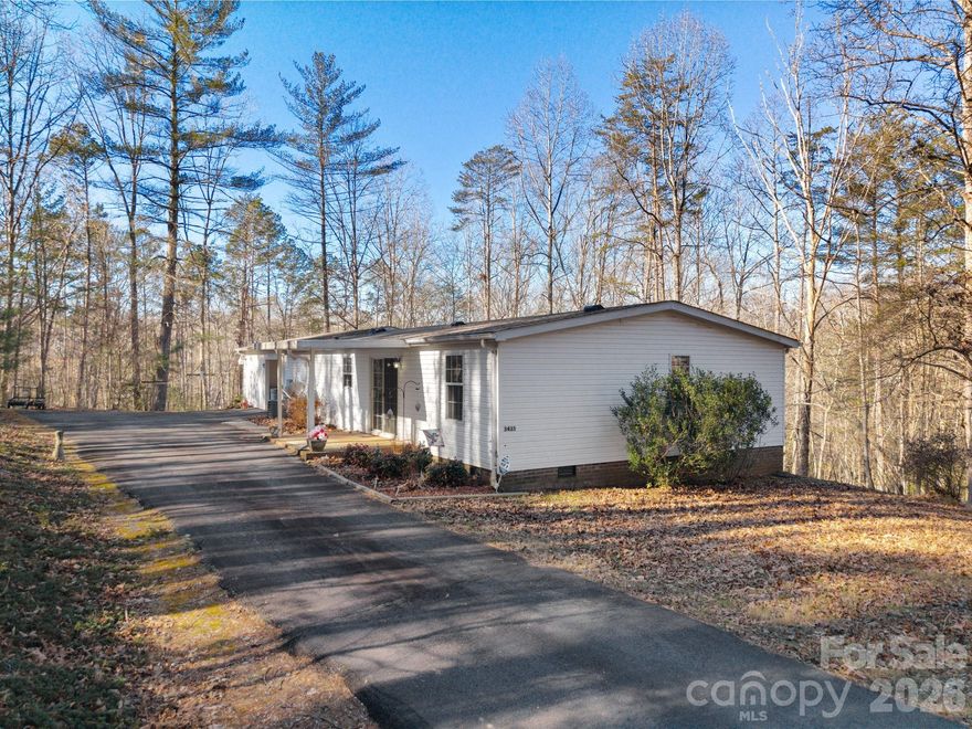 VERY YOUNG BUYERS GOT COLD FEET! Welcome to your new home in the desirable Drexel area, a community within Burke County and adjacent to the mountain town of Morganton! Pride of ownership shines in this well-maintained, three-bedroom, two-bath, double-wide mobile home, owned and lovingly cared for by the same owner for nearly 30 years. New roof in 2024! Sliding glass door by the dining area provides additional light to the home. You won't believe the number of cabinets and storage in the kitchen, including a pantry.  The kitchen is also highlighted by a tasteful ceramic backsplash. At the end of the counter top, an extended dining area is attached for added seating.  Appliances include refrigerator, dishwasher, electric range. The vast living room, with views of the woods, includes a cultured stone, gas fireplace for added coziness during the cold, winter days (gas logs have never been used!). The primary bathroom features a custom walk-in shower.   Ceiling fans throughout!  Central HVAC for added comfort. City water! The residence sits on a private, one-acre wooded lot at the end of a paved, private drive offering exceptional peace and seclusion. A real plus is that this residence is under-bricked for a solid foundation!  Additional awesome features include a single-car carport, a large storage building, and generous outdoor living spaces.  Enjoy the peace and quiet of this neighborhood from the spacious covered front deck.  This property offers a rare combination of privacy and functionality. Long- and short-term rentals permitted. Drexel is an outdoor-activity-oriented community making this home ideal as a full-time residence or a peaceful retreat close to nature.  Sold unfurnished. Drexel centers on outdoor beauty, local history, and community events, with nearby attractions like McGalliard Falls Park, the Waldensian Heritage Trail & Museum, local farms, wineries, Lake James State Park, and the annual Drexel Fair offering nature, culture, and family entertainment.  Additional High Country communities located less than an hour from this residence include Blowing Rock, Boone, Banner Elk, App State University (Hickory & Boone), and Linville (Linville Gorge).  This is an ideal home offering a picturesque location with access to all amenities of the High Country.   Schedule your showing today!
