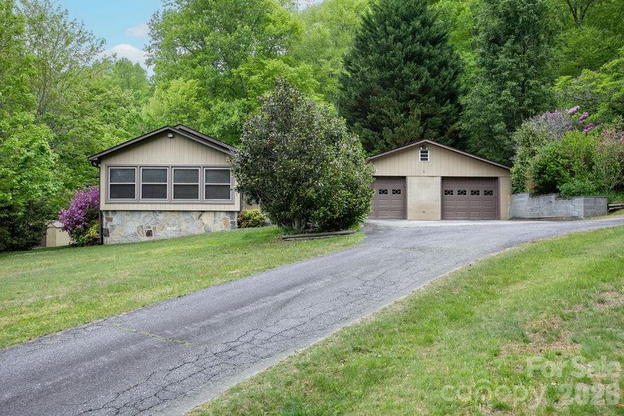 This charming home, built in 1951, has been lovingly owned and meticulously maintained by the same family for nearly 75 years. Their pride of ownership is evident not only in the home itself, but in the beautifully groomed 2+ acre property that surrounds it. The main level offers a functional and inviting layout with everything you need on one floor, including 2 bedrooms, 1 full bath, a comfortable living room, den, kitchen, formal dining area, sunroom, and a spacious mudroom with laundry and an additional shower—perfect for coming in after a day outdoors. Step outside and you’ll find where this property truly shines. Tucked at the end of the road, it offers exceptional privacy with a peaceful, park-like setting highlighted by two small streams, mature landscaping, and established flowering bushes that have been thoughtfully cared for over generations. For those needing space to work or store equipment, the property features a large 2-car detached garage as well as a 1-car basement garage, offering ample room for hobbies, projects, or storage. The expansive yard provides plenty of room for pets, gardening, or simply enjoying the natural surroundings. Above the garage, a separate driveway leads to a dedicated RV site complete with power, water, and a 2-bedroom septic system—ideal for a motorhome, guest accommodations, or potential income-producing use. Conveniently located approximately 7 miles from downtown Brevard and perfectly positioned between Pisgah National Forest and DuPont State Recreational Forest, this property offers a rare blend of privacy, usability, and access to some of Western North Carolina’s most sought-after outdoor destinations.