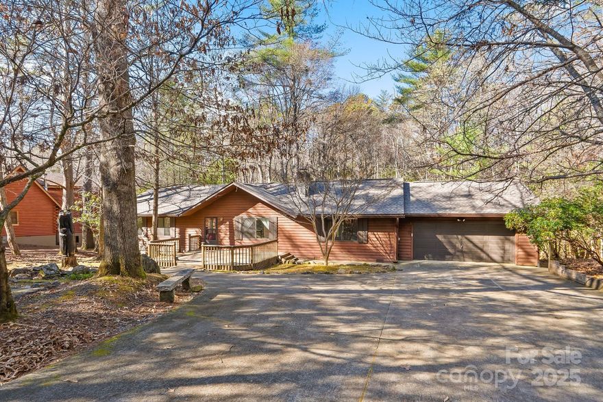 Finally! A One level open split floorplan that is light and bright. Home offers great outdoor space front and back with stone lined trails, a large deck overlooking the stream with small waterfall and pond. The sound is so relaxing. A flat yard with a stream is a rare thing in Connestee Falls. The large sunroom has large windows that let in that warm sunlight. A very comfortable layout featuring 4 bedrooms, 2 and a half baths plus a bonus room, gives great space for year round living or a seasonal home. This home offers new carpet and a new roof (10/2025). Buyer will owe a one-time fee of $13,500 paid at closing to CFPOA.