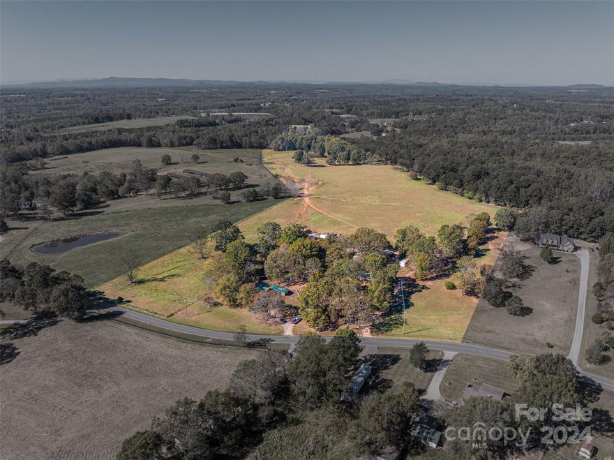 INVESTMENT OPPORTUNITY! Discover a rare haven with limitless potential! This cherished family property for generations, spanning 33 acres, showcases a serene fenced grazing pasture, stunning Sunset mountain views, a brick family single story home, multiple sheds/buildings and five manufactured single-wide home/spaces! Offering approximately 588 feet of road frontage, this invites you to envision a multifaceted investment opportunity: multifamily development, farm, private estate, rentals to add to a rental porfolio, equestrian paradise, or subdivide  and only keep what you want! The fenced pasture, brick house and some trailers are currently rented. Nestled just a few miles from Lincolnton and Cherryville, schools, shopping and the new public libracy, this incredible opportunity awaits your vision to bring it back to its former days! RARE OPPORTUNITY!