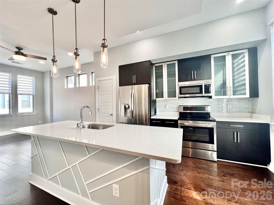 Prime South End living with unbeatable walkability! Tucked into one of Charlotte’s most vibrant neighborhoods, this stunning end-unit townhome places you just steps from restaurants, breweries, shops, offices, and the light rail. It offers the best of South End right outside your door. Inside, thoughtful design and elevated finishes shine throughout. The open main level features beautiful wood flooring and a light-filled great room that flows seamlessly into a showstopping kitchen with a large quartz island, stainless steel appliances, soft-close cabinetry, a tile backsplash, frosted upper cabinet doors, a pantry, and even built-in USB charging ports. A rear enclosed deck offers the perfect private retreat, while a convenient half bath completes the main level. Upstairs, the spacious primary suite is both stylish and functional, featuring built-in shelving, a generous walk-in closet with sliding barn door, additional storage, and a spa-like bath with dual sinks, quartz countertops, an oversized glass and tile shower, and a linen closet. The laundry area is ideally located on this level for everyday convenience.
Additional highlights include an oversized attached garage with extra storage, custom window treatments, upgraded lighting, remote-control ceiling fans, and a newer HVAC (2023). Low-maintenance living at its best with lawn care, trash, water, and sewer all included. This move-in ready gem offers modern comfort in one of Charlotte’s most desirable locations.