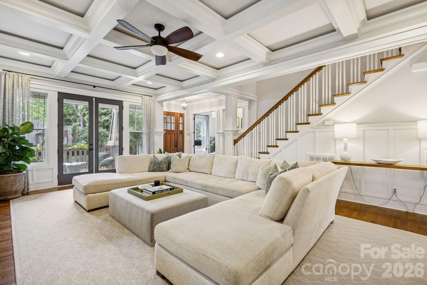 This custom-built Craftsman-style residence has 5 bedrooms and 4 baths. It is Located in the heart of Elizabeth, one of Charlotte’s most walkable and historic neighborhoods. Known for tree-lined streets, character homes, and close proximity to Uptown Charlotte. Just minutes from dining, shopping, parks, Greenway trails, Midtown, Plaza Midwood, Atrium Health and Carolinas Medical Center. The home includes two primary suites, one on the main level and one upstairs, along with spacious secondary bedrooms with walk-in closets. The layout provides flexible living with guest accommodations, office options, and multiple indoor and outdoor gathering areas. Inside, refined craftsmanship includes ten-foot ceilings, oak hardwood floors, designer lighting, and custom cabinetry throughout. Natural light fills the living spaces through well-placed windows and French doors. The foyer opens into a spacious great room with a fireplace, built-in cabinets, coffered ceilings, and detailed woodwork. French doors provide access to the front porch and create a strong connection between indoor and outdoor living.Near the foyer is a private office or guest bedroom with access to a full bath and powder room. The chef’s kitchen features KitchenAid range, retractable blinds, marble countertops, custom cabinetry, beverage refrigerator, and an oversized center island. The kitchen flows into the dining and living areas, creating an open layout ideal for everyday living and entertaining.
Glass doors open to a covered deck alcove with a king-size hanging bed and wall-mounted television, extending the living area outdoors. A pantry and mudroom provide additional storage and a convenient transition space between the kitchen and the outdoor courtyard. The main-level primary suite includes a custom walk-in closet and private bath. Upstairs, a large central media loft connects four bedrooms, including the second primary suite with a spacious bath. Secondary bedrooms are generously sized and include walk-in closets. Laundry rooms are located on both the main and upper levels.Outdoor living includes several comfortable gathering areas. A covered courtyard features a stone gas fireplace and connects to a landscaped backyard with artificial turf, attractive shrubbery, privacy fencing providing a safe place to play. A wraparound back porch leads to a breezeway connecting the home to a detached two-car garage. Above the garage is a fully equipped apartment.  The suite includes a kitchen, bath, laundry, and living space, ideal for guests, office, nanny or rental income. An elevated front yard with a stone stairway leads to the front porch overlooking the neighborhood.This home offers a rare opportunity to own a spacious and flexible Craftsman-style residence with guest quarters in one of Charlotte’s most desirable and connected neighborhoods.