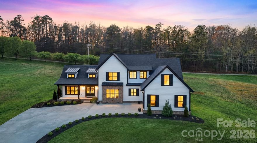 This **2022 modern farmhouse** in Wittenburg Landing is filled with thoughtful design, upscale finishes, and all the bells and whistles to impress even the most discerning buyer. A charming covered front porch welcomes you into a stunning great room featuring soaring cathedral ceilings and a dramatic floor-to-ceiling fireplace mantel with electric insert, creating a warm yet sophisticated focal point.
The open-concept layout captures views of both the front and back yards and flows seamlessly to the rear patio—perfect for relaxing or entertaining. The kitchen is the heart of the home, showcasing a massive center island, gas range with pot filler, open display shelving, custom cabinetry, and a spacious formal dining area just steps away.
Tucked down a private hallway, the primary suite offers a true retreat with a soaking tub, tiled shower, double vanity, and an expansive walk-in closet. Just beyond, you’ll find an exceptional laundry room designed to make everyday living effortless, beautifully appointed with ample workspace and conveniently located off both the main hallway and the primary closet, making laundry feel less like a chore and more like a thoughtfully designed part of the home.
The main level is completed by a double garage, mudroom, and half bath for everyday functionality.
Upstairs, a loft-style den provides additional living space along with three generous bedrooms, each with private bath access, ideal for family or guests.
Outside, professionally landscaped grounds sit on a 0.86-acre lot within a sought-after waterfront community just 2 minutes from Taylorsville Beach. This home blends the perfect modern farmhouse charm with relaxed lake-area living.