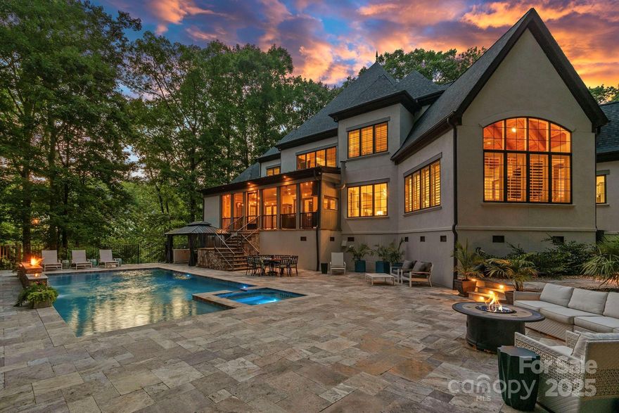 European-inspired stone château tucked among lush landscaping at The Sanctuary on Lake Wylie. Tall arched windows fill the home w/ natural light, highlighting its timeless architecture. Resort style oasis w/ cool underfoot  travertine, sparkling pool, fire-over-water feature, spillover spa, tanning ledge, stone lanai with screened grilling area and fireplace. 4-bay attached and 3-bay detached garages with workshop and half bath. Inside, a sweeping staircase, elevator, built-ins, vaulted/coffered ceilings, and fireplaces add charm. The chef’s kitchen offers commercial-grade appliances, butler’s pantry, coffee bar, and walk-in pantry. Main level features dining room, office, den, breakfast area, 300-bottle wine cellar, laundry, and luxe primary suite with Vant panels, stainless soaking tub, open air double shower, and custom closet. Upstairs: ensuite bedrooms, bonus wing, and more. Enjoy The Camp’s impressive 17-acre waterfront with unmatched amenities, details on the feature sheet.