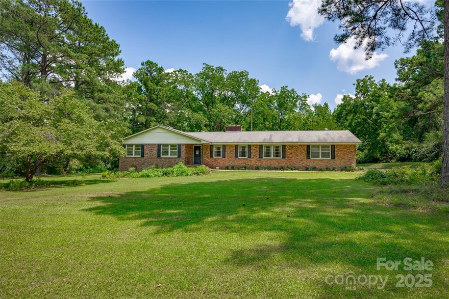 10 Acres!! If you’ve been searching for elbow room, privacy, and potential without being in the middle of nowhere, this one checks every box. Located just 30 minutes from downtown Columbia, under 10 minutes to I-77, and an easy 15-minute drive to Lake Wateree, this 5-bedroom, 2.5 bath brick ranch is set on 10 acres and is full of promise. The home is solid (built in 1965), livable, and waiting on someone ready to roll up their sleeves and bring it back to life (think refinished floors, updated bathrooms, and a kitchen tailored to suit your style). The 5th bedroom is a converted garage with its own entrance, two closets, and endless possibilities - game room, man cave, homeschool classroom, guest or in-law suite. Out back sits a former veterinary building. It hasn’t been used for quite some time,  but it’s still standing and could become anything you need: workshop, studio, barn, or storage. This property is for anyone wanting space, peace, and is ok with a project. NO HOA!