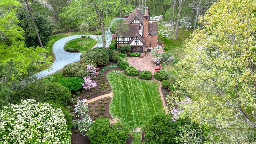 Welcome to Eastover—an extraordinary 1934 Tudor estate designed by renowned architect Louis H. Asbury, gracefully set on private, park-like grounds rich in history, character, and timeless architectural detail. This one-of-a-kind property blends the elegance of a bygone era with thoughtful updates for modern living. Approaching the home, the striking Tudor façade showcases cast limestone, half-timber gables, and distinctive architectural elements that set the tone for what lies within. Inside, craftsmanship is immediately evident—from imported German oak doors to hand-wrought steel staircase balusters and a sweeping curved staircase with walnut handrail. The main level is designed for both grand entertaining and comfortable daily living. A beautifully appointed living room, formal dining room with access to the flagstone terrace, and a richly paneled library overlooking the gardens create an inviting and sophisticated atmosphere. The kitchen has been thoughtfully updated and features custom cabinetry, unique architectural details, and direct access to a charming, screened porch—perfect for relaxed indoor-outdoor living. The home offers multiple gathering spaces, including a warm den with built-ins and hidden details, along with expansive patio areas ideal for entertaining. The original and preserved elements throughout the home—including stonework, tile, fixtures, and millwork—reflect a level of craftsmanship rarely found today. Upstairs, the private quarters include multiple bedrooms and baths, offering flexibility for a variety of living arrangements. A spacious third-floor bonus room provides additional living or recreation space, while the basement features functional areas including laundry, storage, and a wine cellar. The grounds are equally remarkable, originally cultivated with a wide variety of plantings including mature trees, flowering specimens, and natural landscape features. Outdoor living is enhanced by brick terraces, garden areas, and beautifully designed hardscape elements. A separate guest house, originally guest quarters, adds versatility for guests, extended stays, or private workspace. Steeped in local history yet thoughtfully maintained and updated over time, Eastover presents a rare opportunity to own a truly distinctive estate offering privacy, character, and enduring architectural significance.