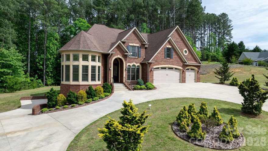 Welcome to 4 Royal Vista Way in River Bend, a premier Lake Hickory community in Granite Falls. This exceptional all-brick home offers 4 bedrooms, 6 full bathrooms, and approximately 4,575 square feet of living space in addition to a massive unfinished basement. A stunning, sun-filled parlor just off the entryway creates a memorable first impression, leading into a thoughtful floor plan that includes a formal dining room, a family room with a fireplace, and a kitchen designed for effortless entertaining.

The kitchen is a standout feature, boasting an abundance of cabinet and counter space, high-end stainless appliances, a high capacity vent hood, a gas cooktop, and a pot filler for added convenience. The open sightlines into the family room create an inviting, airy atmosphere that is perfect for hosting large gatherings. The main level also provides a convenient primary bedroom suite, an additional full bathroom, and a spacious laundry room.

The elegant staircase offers access from two directions, lending a stately presence to the home’s interior. Upstairs, the second primary bedroom serves as a true retreat with double doors, tray ceilings, and custom lighting. The highly appointed bathroom features a custom tile shower and a large vanity area overlooking the wooded area behind the home, while the walk-in closet offers generous proportions rarely seen in other homes. Two additional bedrooms, two more bathrooms, and a versatile bonus room provide ample space for family or guests to spread out.

The walk-out basement is a true blank canvas with high ceilings and a bathroom that is already finished and ready to go, making it easy to create a custom recreation area or additional living quarters. Set on approximately 0.89 acres, the property features a beautiful horseshoe driveway, generous parking, and an attached 3-car garage. Residents enjoy nearby community lake access, a boat ramp, and a well-hidden boat storage area across the street with options currently available. This location offers the best of both worlds, providing a peaceful community setting just minutes from the shopping, dining, and charm of Downtown Hickory.