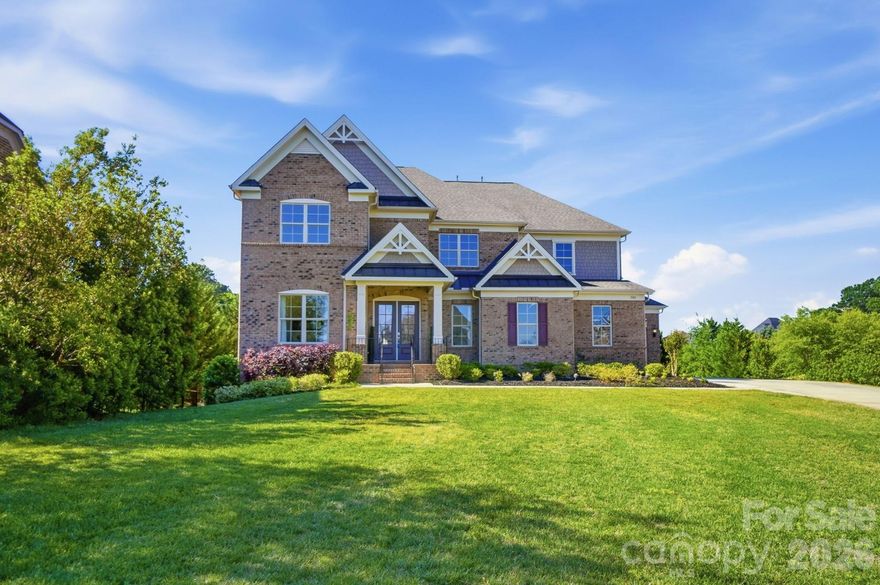 Located in the highly sought-after award-winning Marvin school district and nestled within one of the area’s premier gated communities, this beautiful home offers a rare blend of sophistication, warmth, and versatility—set in the vibrant community of Marvin.

The welcoming foyer adorned with wainscoting and a sweeping curved staircase sets an elegant first impression. The dramatic two-story dining room is perfectly suited for hosting and is complemented by a stylish bar/butler’s pantry featuring a beverage refrigerator, glass-front cabinetry, and a secondary pantry. Crown molding and hardwood floors throughout the home reflect timeless craftsmanship and thoughtful design.

Designed for both everyday comfort and effortless entertaining, the gourmet kitchen serves as the heart of the home. Appointed with a large center island, abundant cabinetry, gas cooktop with hood, wall ovens, and a walk-in pantry, it opens to an expansive breakfast area and flows seamlessly into the spacious great room. Here, coffered ceilings, a striking stone fireplace, and a picturesque wall of windows create a warm and inviting atmosphere. Step outside to the large deck overlooking the private backyard—an ideal setting for gathering, dining, and relaxing.

The 2400+ square foot fully finished basement is truly a standout feature and unlike anything else in the neighborhood. Complete with a kitchenette, theatre room, expansive game and entertainment areas, en-suite bedroom, and generous spaces ideal for fitness, creative pursuits, or special events, this level offers exceptional versatility. Whether hosting lively gatherings or accommodating multi-generational living, the possibilities are endless.

All six bedrooms feature private en-suite baths and walk-in closets, providing outstanding comfort and privacy. A main-floor guest suite allows for convenient first-floor accessibility. Upstairs, a spacious loft offers a relaxed secondary living area, while the primary suite serves as a serene retreat with a sitting room, tray ceiling, spa-inspired bath, and dual walk-in closets.

The large backyard provides ample space for recreation and celebration. Additional highlights include a private main level home office, generously sized laundry room, built-in study station, drop zone, expansive driveway for guest parking, and a three-car garage with abundant storage.

With Marvin’s welcoming atmosphere, exceptional schools, and refined community setting, this home offers more than beautiful spaces—it offers a lifestyle defined by connection, opportunity, and distinction.