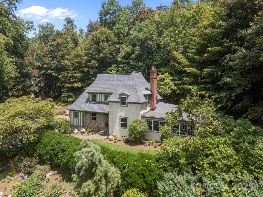 Adjoining parcels in Beaverdam! Welcome to "Glen Campbell" - a rare French Tudor Retreat in North Asheville.  Nestled on 2.5 private acres, just minutes from downtown, Blue Ridge Parkway, shopping, medical and all other needed conveniences. The property for sale is comprised of 2 separate tax parcels with frontage on 2 public streets. Set above a professionally landscaped yard featuring natural boulders, rock walls, and serene stone patios, including a cozy firepit. The property's unique setting overlooks a large undeveloped tract that includes an historic 1800's log cabin under a long-term family trust agreement providing a tranquil setting and undisturbed view. In 2011, the home was tastefully updated with a stunning new kitchen and dining area, a modernized primary suite, office area and a convenient new half bath- all while preserving the home's original architecture and charm.  This is a one-of-a-kind North Asheville gem with timeless appeal!