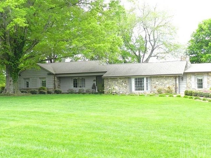 Gorgeous, sprawling ranch offers stunning views from many rooms. 4BR/3BA, split plan has lots of natural light. Master suite is large & bright. Sunken living room with vaulted, beamed ceiling & stone fireplace. Kitchen has brick surround, tile backsplash & opens to dining room. Den off kitchen has wood floors & walls. Extra large sunroom has long-range mountain & lake views. No city taxes. City water & sewer available.