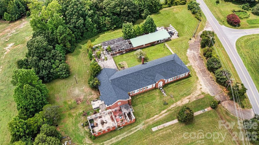 A rare opportunity to breathe new life into a piece of local history. With its size, history, and flexible zoning, this is a truly one-of-a-kind offering in today’s market.

Situated on more than 5 fully fenced acres in northern Iredell County, this former schoolhouse offers nearly 22,000 square feet of character, scale, and untapped potential. Opportunities like this rarely come available — and for the right buyer, the possibilities are truly extraordinary.

The original main building features approximately 7,900 square feet of heated and cooled space, highlighted by 12-foot ceilings, grand archways, and beautifully preserved maple hardwood floors that reflect the craftsmanship of another era. The roof covering this portion, along with the attached gymnasium/auditorium, was replaced approximately seven years ago.

Beyond the main structure, an additional 14,000 square feet of masonry and steel construction provides a substantial and durable footprint ready for restoration, redevelopment, or adaptive reuse. While portions will require roof replacement and improvements, the underlying structure offers a strong and compelling foundation for transformation.

The grounds are fully fenced with two large access gates, offering both privacy and flexibility for a wide range of future uses.

Zoned Residential Agricultural (RA), the possibilities are expansive and may include:

Bed & breakfast or retreat center
Wedding or event venue
Church or private school
Daycare or community center
Agricultural or residential development
Cluster subdivision or mobile home park

For developers, investors, entrepreneurs, or creatives with vision, this is a blank canvas with history, scale, and exceptional potential.

Bring your imagination — and write the next chapter of this remarkable property.