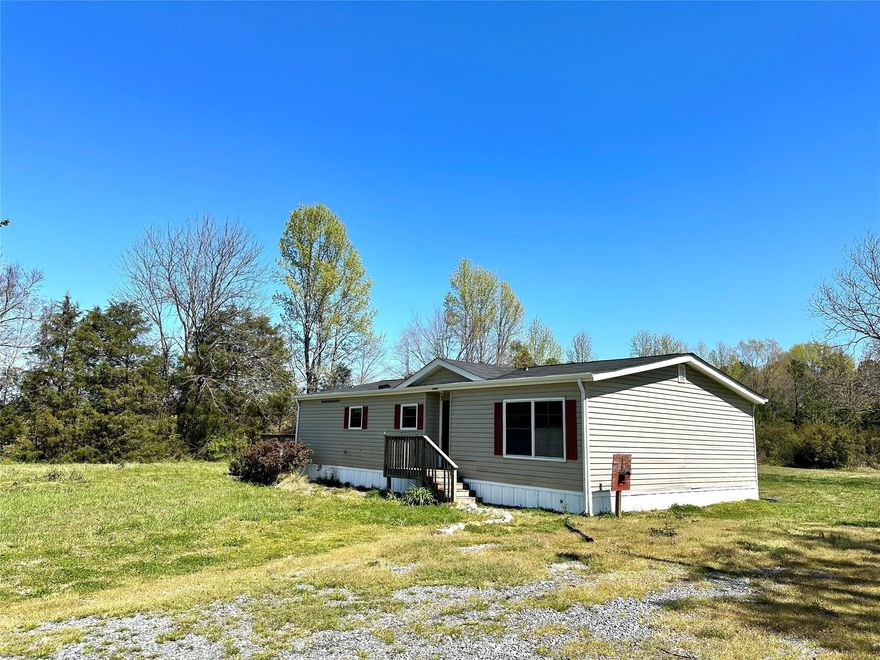 This manufactured home sits on 2.3 acres in a great location right by Buford Schools. The split floor plan is nice and open in the living area and kitchen. The Primary bedroom is a great size and has 2 closets and then the primary bathroom suite. The 2 secondary bedrooms are on the other side of the house and share the 2nd bathroom. There is a Laundry/utility room with cabinets for extra storage. There is a door from the utility room that leads to the nice deck off the side of the house. Outside there is plenty of yard space for things like a garden, but still additional wooded area behind the house as well. This home was previously tenant occupied and is now vacant. A New Roof and New Gutters were just put on in February. There was a previous roof leak but that has now been resolved. The home is in livable condition, but can use some updating and light repairs. Home being sold as-is.