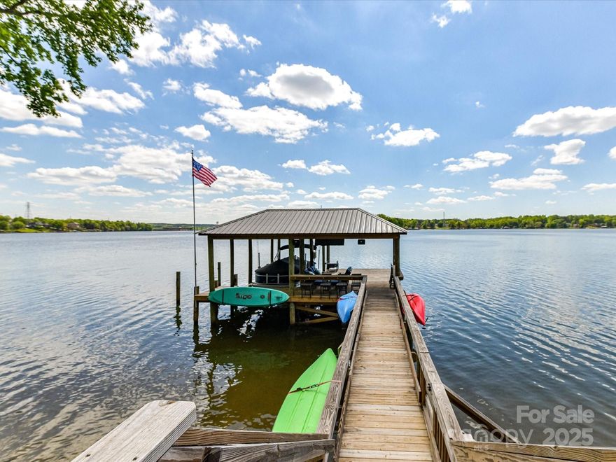 You don't want to miss out on this spectacular waterfront property in Tega Cay! This is a rare find with gorgeous main channel lake views on the Manila Bay point. With 218 feet of water frontage, this one is hard to beat. Check out the new expanded boat dock with boat lift. This home has almost been completely renovated, from the kitchen with its grand island and stunning granite countertops to the primary bath. The home has fabulous features wherever you turn. The lovely lower-level bonus room is a showstopper, which could also be a 4th bedroom with its own private bath. This room features beautifully tiled floors, a wet bar and a murphy bed. Wait until you see the views from the multiple decks along the back of the home. This divine home is located in sought after Tega Cay within the top-rated Fort Mill School district. Tega Cay offers miles of walking trails, golf courses, pickleball & tennis courts, with clubhouse and pool. No HOA! The boat is also for sale! Just move right in!
