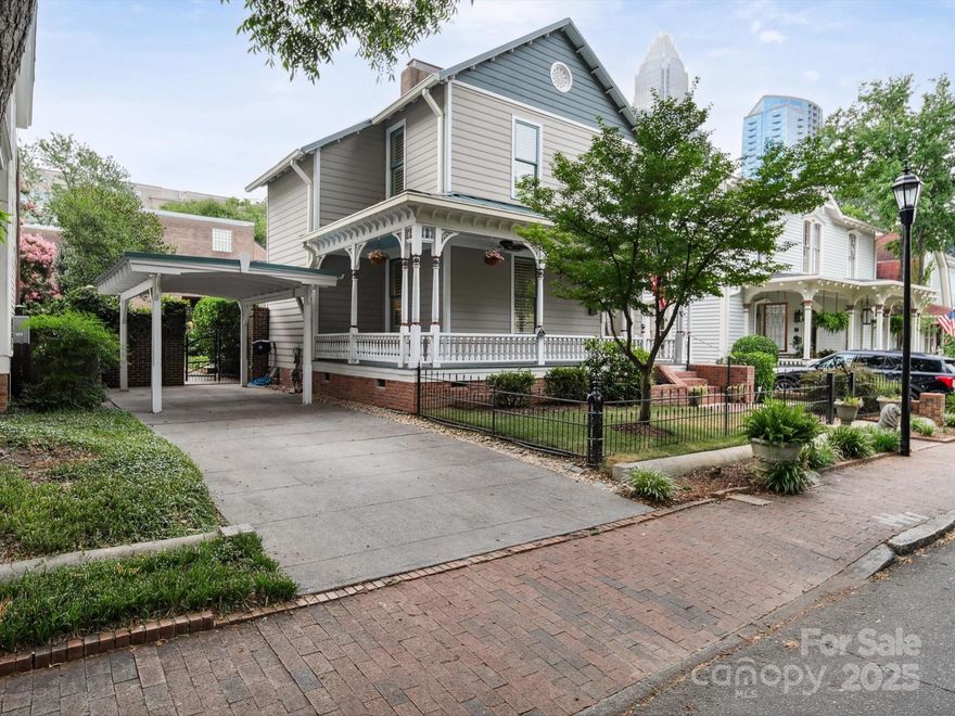 4th Ward Historic Beauty! One of only four site built Victorians in Charlotte’s charming 4th Ward, this unique post-Civil War home blends timeless character with thoughtful modern updates. Stripped to the frame in the 1970s, it was rebuilt with updated wiring, plumbing, and countless upgrades since. A teal 50-year Pro-Panel roof (2004), Kolbe double-hung windows (2005), & Trex decking add lasting value. Enjoy a rare carport + driveway, plus a welcoming wraparound porch with cooling fans and a serene water feature. Inside, the renovated kitchen shines with a massive eat-in island, designer cabinetry, Samsung appliances, granite countertops, a farm sink, and an antique telephone closet sure to spark conversation. A 2022 tankless water heater & mini-split A/C in the loft offer energy-efficient comfort. Freshly painted throughout and filled with charm, this home also offers a fully enclosed backyard ready for your personal touch. All just steps from Uptown, parks, dining, and nightlife.