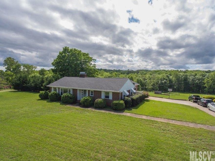 Three Bedroom Brick home with over one acre in Morganton/Drexel area. Home offers Large living room with gas logs. Dining Room.  Vintage/retro style kitchen. Built-in benches and table. Metal cabinets and views of the backyard from the kitchen sink. Large sunroom/den. Laundry room/mud room with access to covered back patio. Hardwood and Tile Floors. Double Garage with workshop area and Walk up storage. Two Full Bathrooms. Interior access to unfinished basement/storage. Level yard with room for entertaining/play or gardening. Updated windows and roof.  Low maintenance.