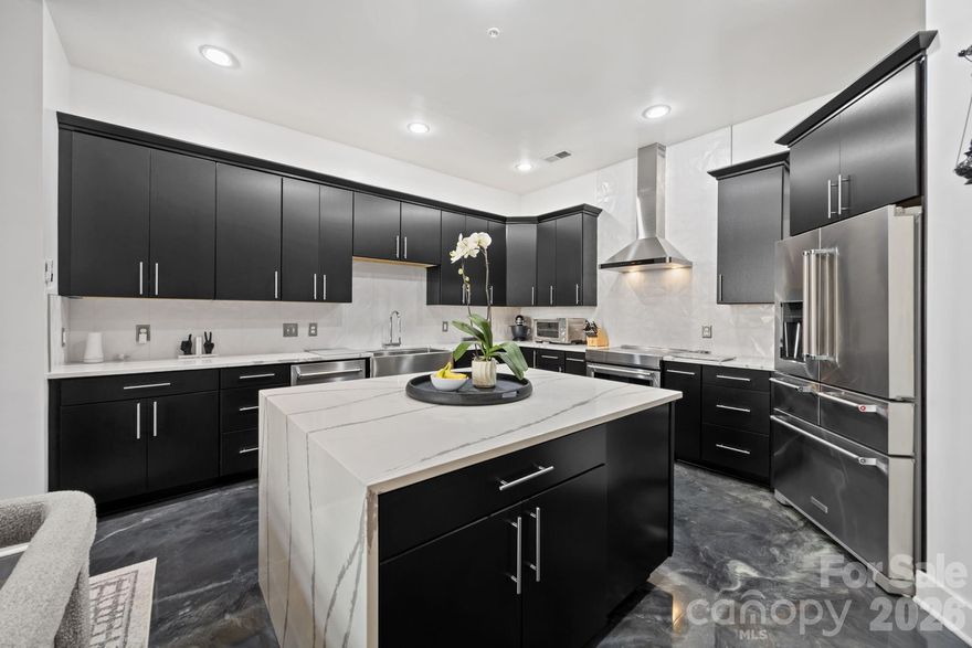 Experience unparalleled urban luxury in this meticulously reimagined 2,000+ square foot condo, perfectly positioned immediately adjacent to Charlotte’s highly anticipated Iron District. Inside this expansive 1.5-story residence, a sophisticated, transitional masterpiece awaits. The main level is defined by striking epoxy resin flooring that flows seamlessly through the open floor plan. The centerpiece of the home is a fully gutted, true chef’s kitchen designed for the culinary enthusiast. It features an elite KitchenAid appliance suite—including an electric induction range and a 5-door refrigerator—custom cabinetry with extensive organizational rollouts, and a stainless steel Vigo farmhouse sink with a cutting board inlay.

Upstairs, new stain-resistant carpeting leads to the ultimate private retreat. The primary suite features a highly customized walk-in closet outfitted with rollout jewelry shelves, dedicated shoe shelving, and reinforced steel rails. The primary bathroom has undergone a full-gut transformation into a resort-caliber spa, showcasing a reinforced quartz stone tub, an extended shower with dual rain heads, a custom anti-fog LED mirror, and a sleek quartz vanity. The guest bath is equally impressive, boasting modern fixtures and a Bluetooth-enabled ventilation and lighting system.

No detail or system was overlooked in the modernization of this home. State-of-the-art infrastructural upgrades include a UV-sanitizing HVAC system with app control, an electric tankless water heater, repaired motorized ventilation windows, and fully updated electrical with integrated USB outlets throughout. Complete with a dedicated laundry area featuring steam-setting LG appliances and custom cabinetry, this Skybox property offers a flawless, turn-key lifestyle at the very forefront of Charlotte's most exciting new development corridor. HOA plans to replace roofs in the near future. No vote or final assessment amount has been determined yet.