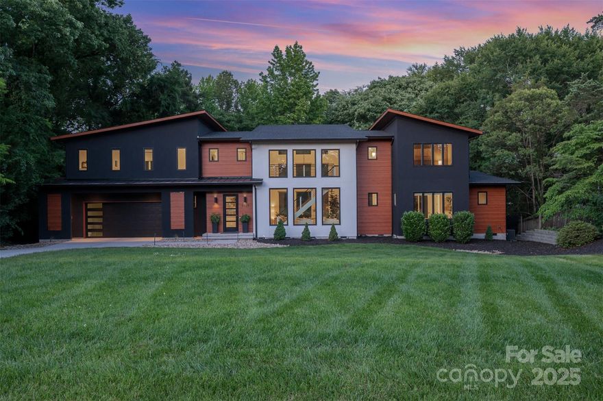 A Modern Marvel in Mammoth Oaks!
Nearly 100 feet long and designed to impress, this architectural gem makes a statement the moment you step inside. Soaring 26-foot ceilings and floor-to-ceiling windows flood the great room with natural light and frame stunning views of the surrounding tree canopy. Both the great room and main-level Owner’s Suite open to a 65-foot deck—ideal for entertaining or simply enjoying the wooded lot. Inside, the kitchen balances sleek design with everyday function: a statement island, oversized walk-in pantry, and appliance counter deliver both style and substance.

The Owner’s Suite features dual walk-in closets, a spa-like bath, and private deck access. A sculptural floating staircase anchors the living space, leading to a second level with a generous media room, guest suite, and two additional bedrooms with a shared jack-and-jill bath.

If you love bold architecture, thoughtful design, and the feeling of being tucked into the trees—this one’s for you.