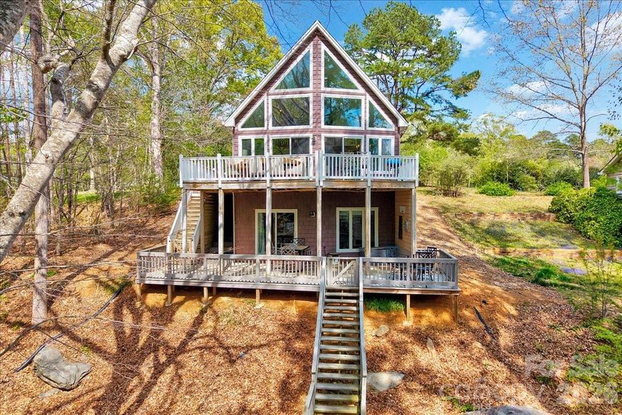 Ultimate Lakefront Retreat – 23234 Swift Island Rd, Albemarle, NC

Get ready to fall in love with lake life! This stunning A-frame waterfront home is the perfect blend of charm, comfort, and adventure—tucked away on a peaceful, tree-lined lot with breathtaking views of the water.
From the moment you walk in, you’re greeted by soaring ceilings and a dramatic wall of windows that flood the home with natural light and bring the outdoors in. The open-concept living, dining, and kitchen area is ideal for entertaining or simply relaxing after a day on the lake. Step right out onto the spacious deck and soak in the views—this is where memories are made!
The kitchen shines with granite countertops, stainless steel appliances, and plenty of space to cook and gather.

Flexible & Inviting Living Spaces
This home offers 2 bedrooms with a unique and flexible layout:
* A loft-style primary suite with its own private bathroom—your own peaceful retreat overlooking the main living area
* A lower-level room currently used as a bedroom, complete with a coffee station—perfect for guests.
* Additional living space downstairs provides a great bonus area for movie nights, game days, or extra sleeping space

Outdoor Living & Lake Lifestyle
The outdoor spaces truly steal the show:
* Expansive upper and lower decks for entertaining
* Covered porch for shaded relaxation
* Private dock with covered boat slip
* Brand new decking on the top level of the dock—perfect for sunbathing or hosting friends
Whether you're boating, fishing, kayaking, or just unwinding by the water, this property delivers the full lakefront experience.

Location Perks – Fun Around Albemarle &  Lake Tillery
Living here means you’re not just buying a home—you’re stepping into a lifestyle:
* Lake Tillery – boating, fishing, paddle boarding, and endless water fun right outside your door
* Uwharrie National Forest – hiking, camping, off-roading, and scenic trails just a short drive away
* Old North State Club (nearby) – premier golf with stunning lake views
* Downtown Albemarle – local dining, shops, and small-town charm
* Known for great fishing—largemouth bass, crappie, and more

Whether you’re looking for a full-time residence, weekend getaway, or income-producing vacation rental, this lakefront gem checks all the boxes.