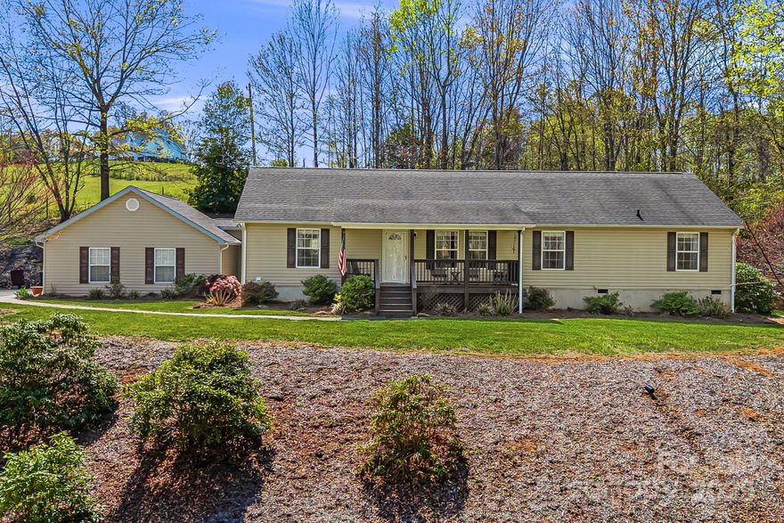 A very spacious home w/plenty of storage on a private lot. You'll appreciate the covered rocking chair front porch w/winter mountain views. Laminate wood floors throughout most of the home featuring an open concept & split bedroom floorplan, there are two living areas, one has a gas log fireplace. Lots of windows throughout for plenty of natural light, the kitchen features an island as well as breakfast bar & dining room off the kitchen. Back deck is accessible directly off the kitchen/dining area & is a great, convenient place to grill out or entertain guests. The Primary bedroom has an en-suite full bath, & the there is a second full bath in between bedrooms 2 & 3. A laundry/mud room is off kitchen & the garage is accessible directly via laundry room. Oversized 2 car garage has lots of room & plenty of storage with pull down attic stairs. Sellers offering home warranty. See video here: https://listings.wncrealestatephotography.com/videos/01963ce6-7de6-727a-a353-5a57ded6d30f