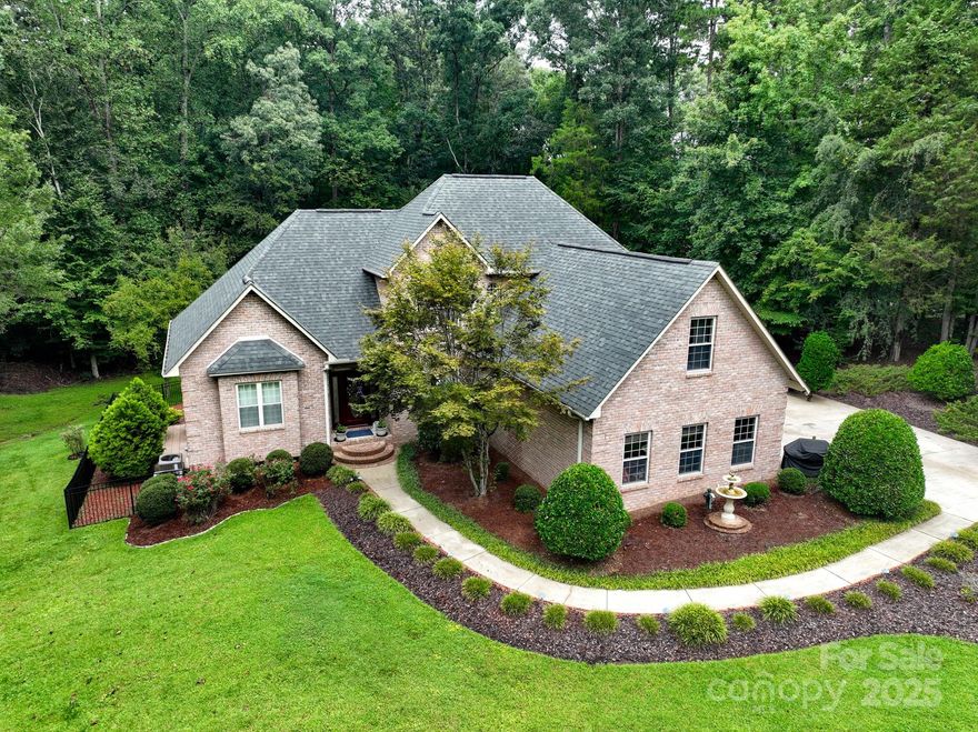 PRIVATE PARADISE in the River Walk community of High Rock Lake!! This home offers both comfort and elegance, featuring a spacious primary suite and well thought through floor plan. The gourmet kitchen offers QUARTZ COUNTERTOPS/CUSTOM WOOD CABINETRY/ELEGANT GLASS UPPER DOORS/CENTRAL ISLAND W/COOKTOP/DOUBLE OVENS. Expansive windows across the back of the home flood the space with natural light and views of your outdoor sanctuary. Upstairs you'll find two additional bedrooms with walk in closet space,  a full bathroom,  and a large bonus room. The walk-out basement adds  flexibility with UPDATED FLOORING, a FULL BATH W/TILE SHOWER opening into a spacious room with a closet, a large living/ entertaining space,  and MODERN SLEEK PAINTED CEILING BEAMS. The additional square footage/ plumbing access in the basement, opens the door of creativity for the space for a new homeowner. The resort-style backyard features lush landscaping surrounding a sparkling in-ground pool w/ designer stonework & subtle lighting. The outdoor space creates a serene atmosphere for evening relaxation. As part of the River Walk community, you’ll enjoy access to a private boat ramp—making it easy to enjoy life on beautiful High Rock Lake.