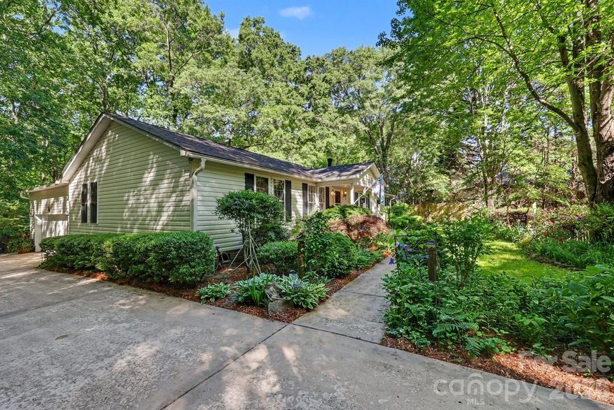 Tucked away on 2.7 (consisting fo 3 parcels) private acres in Matthews, this one-of-a-kind property offers a rare opportunity to enjoy a peaceful, nature-filled setting with established gardens, winding paths, and multiple outdoor living spaces.
Designed for those seeking a more intentional lifestyle, the grounds feature dedicated garden areas, mature landscaping, and space to create your own backyard retreat. A barnlike outbuilding provides flexibility for storage, workshop, or hobby use.
The home offers 4 bedrooms, split-bedroom layout. The 4th bedroom is currently set up as a home office with built-ins—ideal for remote work or flex space. The spacious primary suite features a large bath with walk-in shower. Wood flooring runs throughout, adding warmth and continuity to the living spaces.
Envision garden-to-table living, quiet mornings surrounded by nature, or simply room to breathe---only minutes aways from everyday amenities located near the corner of Idlewild Road and Margaret Wallace Road!