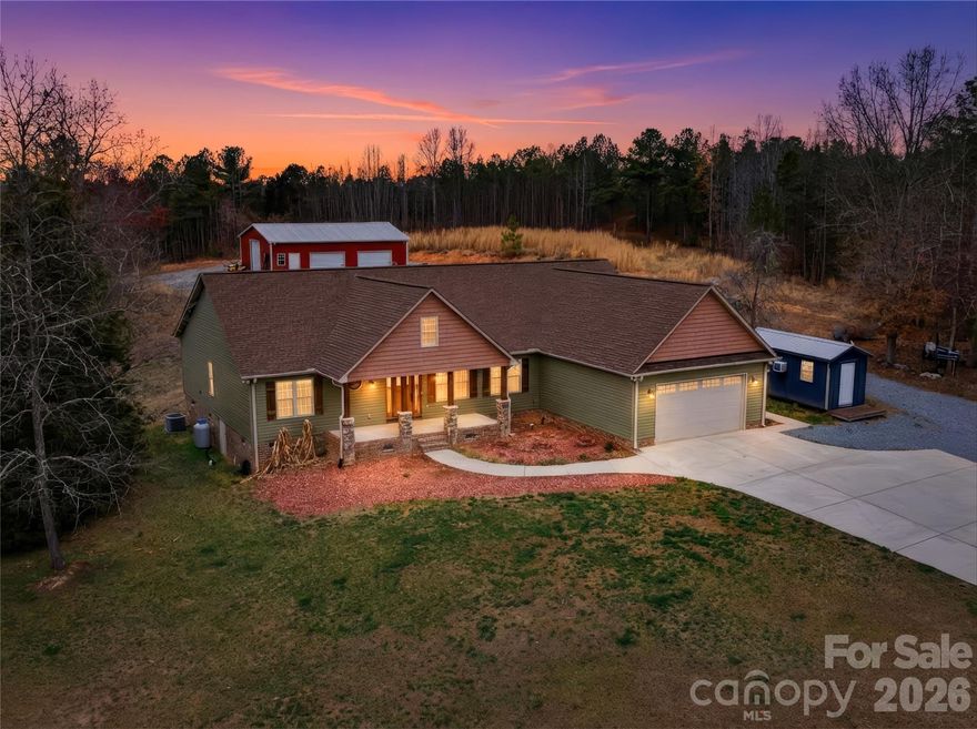 Set on more than 18 private acres with a small creek winding through the property and a long private driveway behind a gated entrance, creating a grand approach, this custom-built 3 bedroom, 2.5 bathroom home offers exceptional privacy, natural beauty, and a thoughtfully designed open floorplan connecting the kitchen, dining, and living areas for effortless everyday living and entertaining. The split layout places the primary suite on one side and two additional bedrooms plus a versatile office/bonus room on the other, providing both privacy and functionality. The kitchen boasts stainless steel appliances, a flat-top electric cooktop, built-in convection ovens, pantry storage, a center island, and stylish pendant lighting, while the living room is anchored by a warm, inviting fireplace. Hardwood flooring runs throughout most of the home, enhancing the warm and refined interior. The primary suite is a luxurious retreat with dual vanities, a soaking tub, separate shower, walk-in closet, and direct access to the screened porch, also accessible from the living area, creating a seamless indoor-outdoor living space perfect for quiet mornings or relaxing evenings. Additional outdoor features include a spacious rear deck finished in durable Trex decking, a welcoming covered front porch, and a dedicated sandbox play area, all surrounded by a beautiful blend of wooded areas, open land, and pasture views, with room for horses, small-scale farming, or other outdoor pursuits. The attached double garage offers extra storage, and the impressive 30x40 detached garage/workshop features three bays and 100-amp electrical service, providing outstanding space and power for equipment, hobbies, or projects. A rare opportunity to own a private, estate-style retreat that combines refined comfort, striking setting, and room to truly live.