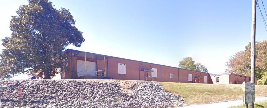 Prime location on a hill overlooking Patton Park and the Ocklawaha Trail in the rapidly developing section of Henderson County, just outside of the Hendersonville City Limits, but still near downtown Hendersonville.  Two parcels included, Tax Pin# 9569644321 & 956944182 for a total of approximately 3.55/ac.  The property is mostly level with lots of area for parking around the building and an expandable parking area behind the building.  The main building had a new roof installed in 2021.  The main building is 32,400/sf with 2,700/sf of office area for a total of 35,100/sf.  Building has 2 truck docks and a roll-up door in the main building with 12' ceilings.  Many possible uses in this high growth area. Call the listing agent for all showings.  Existing Roof Warranty.