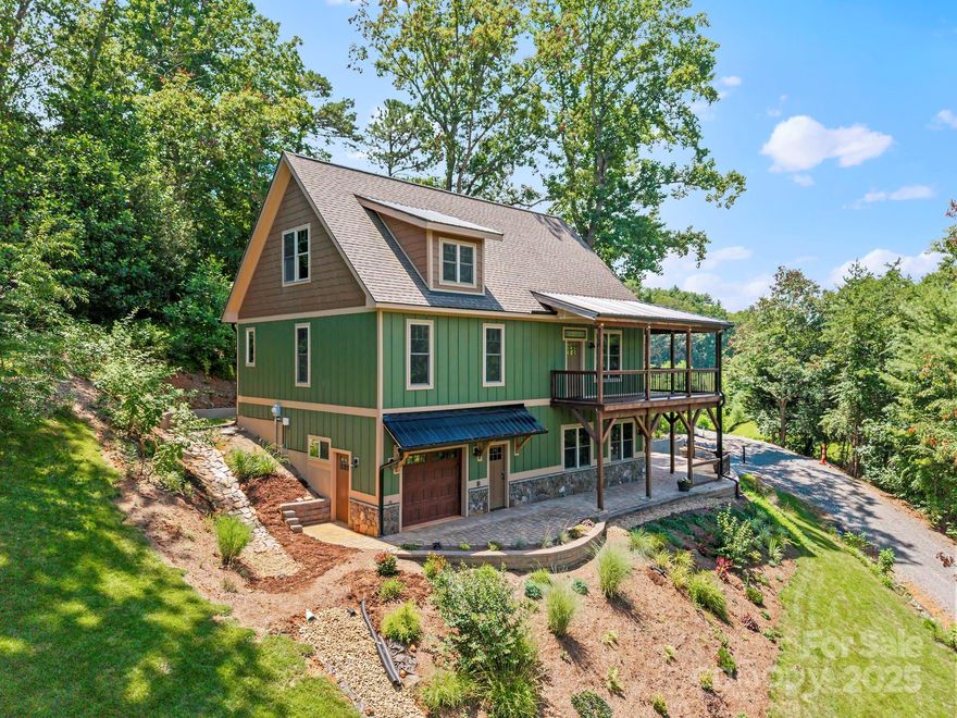 Immaculate LIKE NEW Arts & Crafts home with beautiful year-round mountain views and refined indoor-outdoor living. Enjoy the tranquility of a wraparound covered deck and lower-level custom patio, surrounded by professional landscaping. The main level impresses with soaring vaulted ceilings, rich natural light, and expansive windows that frame the mountain scenery. A stacked stone fireplace anchors the living room, while the rustic/modern kitchen offers custom wood cabinetry, a hand-crafted backsplash, and an island with seating. The oversized primary suite features a barn door entry to a walk-in closet and a spa-like en suite bath with dual vanities and a tiled walk-in shower. A versatile loft overlooks the main living area, ideal for an office, studio, or guest space. The finished lower-level functions as private quarters with a family room, kitchenette, game area, bedroom, bath, and separate entrance. The garage is suited for a workshop or storage area. Just 25 minutes to Asheville.