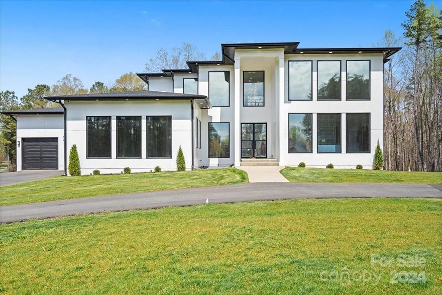 Minutes from Ballantyne is a sprawling 4-acre plot which is eligible to be parceled out for a profit, stands a stunning modern home boasting four bedrooms, three and a half baths, with over 6,700 sqf, and an array of luxurious features. The exterior, with its sleek lines and minimalist design, hints at the contemporary elegance found within. You are greeted by the radiant glow of polished marble floors that extend throughout the main level. The open-concept living spaces are bathed in natural light streaming through expansive windows, offering panoramic views of the surrounding countryside. The kitchen is a chef's dream, equipped with state-of-the-art appliances, sleek cabinetry, and a spacious island. The four bedrooms provide ample space for relaxation, while the master suite boasts a spa-like ensuite bath. Downstairs, an unfinished basement holds endless potential for customization. This home has too many specialties to count, so please refer to the special features sheet attached!