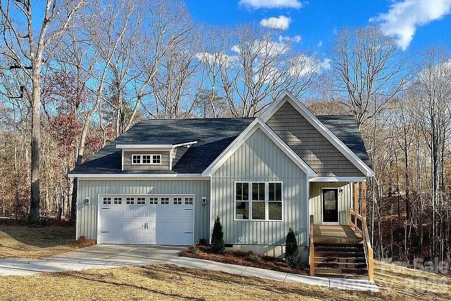 This gem proudly sits on over 2 1/2 wooded acres with a stream. Located in desirable Iron Station, in a small neighborhood, with no HOA, it has quick access to hwys 27, 321 & 73. Built and designed with love by a small family builder, you will notice the difference immediately with details throughout the home like solid wood beams, custom cabinets and tile, your home will truly be unique. The tall crawl space has ample storage and a full size door for access. The 258 square feet of covered porches have fans and beautiful solid wood post and handrails. The house floods with natural light thanks to abundant windows.