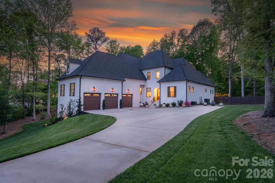 Welcome home to this stunning, custom French Provincial home offering refined design, modern comfort, and exceptional space. Situated on over an acre, luxury living meets peaceful surroundings near Lake Wylie in the beautiful community of Carolina Coves. Luxury abounds in the high-end finishes and custom design, making this home stand out. The main level includes a spacious primary suite and an additional bedroom, ideal for flexible living arrangements. Primary retreat features a gorgeous spa-like bathroom and custom closet for maximum relaxation and organization. The gourmet kitchen boasts a large island, walk-in pantry, and seamless flow into the dining area and inviting great room, complete with a cozy fireplace—perfect for hosting gatherings or relaxing evenings at home. Upstairs, you’ll find two additional bedrooms, each with their own private bathroom, and a generous bonus room which provides endless possibilities for a media room, home office, or playroom. The bonus room also features walk-in attic access for easily accessible storage space, or it could also be finished to create additional living space. The oversized 3-car garage will hold not only your cars, but also your lake toys, tools and additional storage space. Step outside to enjoy the beautifully landscaped and private fenced backyard and serene setting, offering the perfect backdrop for outdoor entertaining. You can relax on the covered back porch or step down onto the beautiful stamped concrete patio to enjoy this outdoor space. Lake Wylie access is just one mile away at Morningstar Marinas McLean. Lake life meets the perfect combination of refined features and comfort in this spectacular home. Zoned for the new Lake Wylie High School slated to open in August 2026.