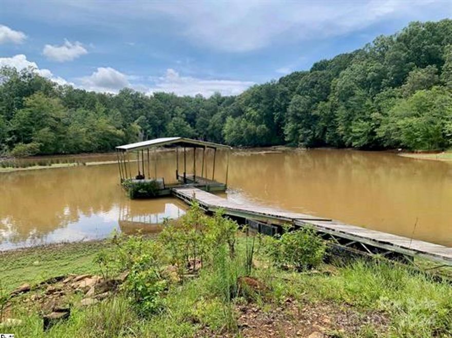 Waterfront with dock home Owner Financing Available 10% down on this Fishermans Dream home... Lowest priced waterfront home with views and deeded covered private dock. Owner finance available. Adorable cozy home located on Three and Twenty Creek with access to Lake Hartwell. NO HOA..  The property is a gentle slope to the lake with beautiful views. Large deck with amazing views. one year new HVAC and Duct work, roof resealed in April 2023, large built smoker, Storage shop/ shed with roll up door, Large covered car-port. Great for fishing or just plain sitting and taking it all in.  This home would make a wonderful primary residence, a weekend getaway, or even a lucrative vacation rental.  Currently run as an Air BNB. Comes fully furnished just the way you see it. This is a mobile home and is certified. Hurry as this wont last long. 
Has a carport with very large storage or workshop.  Great for fishing gear, tools and storage.Seller is licensed Real Estate Agent in South Carolina