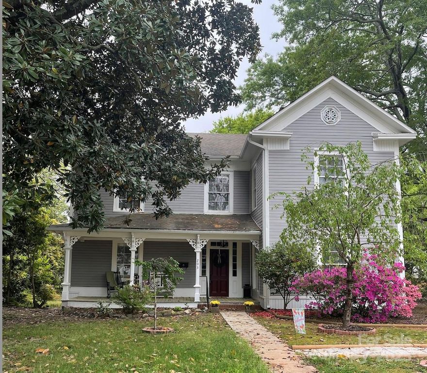203 Kings Mountain is ready to captivate those who appreciate the glamour of yesteryear & appreciate its grandeur, restoration & exceptional livability.  This 1880's piece of history exudes southern charm & hospitality.  Inside you will love the high ceilings, orig. heart of pine wood floors & the spacious foyer w/the original wooden staircase.  There are 7 FP's but 5 have been capped off.  The LR & DR have gas logs.  The kitchen boasts a walk-in pantry, stainless steel appliances & lots of windows.  Flexible dining space off kitchen—ideal as dining, den, or extra living area. The Primary Suite is on the main floor.  The bath has double vanities & a tub/shower.  Upstairs there are 3 BRs & a full BA w/claw foot tub.  Outside you will find a det. 2 car carport & a storage building being sold "as is".  Huge trees surround this lovely home w/ the focal point being the 100+ yr old magnolia tree in the front yard.  You will love the prime in-town location, close to elementary school, restaurants, shops, & parks.  Don't miss the opportunity to own this historical home in Downtown Clover.