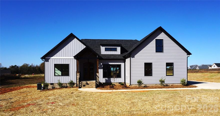 Step into this stunning modern custom home, where contemporary design meets an expansive open floor plan. Nestled on a level half-acre lot in a sought-after neighborhood, it offers the perfect blend of low county taxes and minimal HOA fees. Inside, you’ll find rich wood floors and striking ceiling transitions—from coffered to tray—highlighting meticulous architectural details. The open layout seamlessly connects the living area, breakfast nook, and formal dining room. At its heart is a gourmet kitchen with quartz counters and a show-stopping 12-foot island, perfect for entertaining. The split-bedroom design ensures a private primary suite, a true retreat featuring a spa-like bathroom with a custom walk-in shower, dual vanities, and a spacious walk-in closet. The side-load two-car garage boosts curb appeal and offers ample parking on the large driveway. Finally, unwind on the covered rear porch, the perfect setting for morning coffee or evening sunsets. With Everlast siding offering 25 years of maintenance-free living and a lifetime warranty to the original owner, this home is more than just a house—it’s a statement of luxury. Don’t miss it!