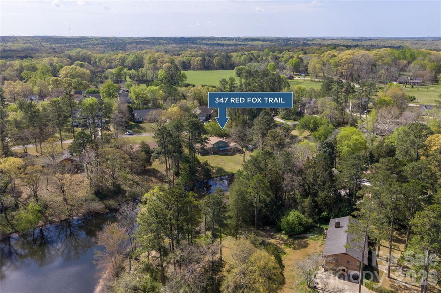 Talk about character & southern charm! This 4 bedroom 3 bath split level home sits on .67 of an acre on a pond in Country Club Estates. There is plenty of room to spread out with multiple living spaces. The lower level den features a gas log fireplace, built in shelving, and sliding doors that open to the spacious backyard and peaceful pond. The upper level includes three bedrooms and two full baths. The primary suite offers a dressing area and two closets. Recent updates include fresh paint inside and out, updated kitchen counters, new flooring, and a new utility sink in the laundry room. If you love a cozy, well built home with timeless charm and a peaceful setting, this one is a must see!!