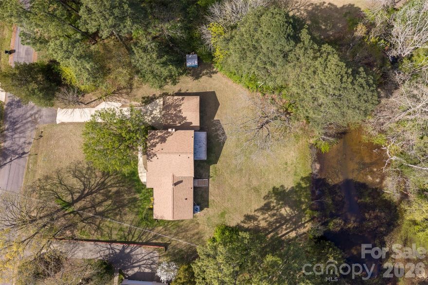 Talk about character & southern charm! This 4 bedroom 3 bath split level home sits on .67 of an acre on a pond in Country Club Estates. There is plenty of room to spread out with multiple living spaces. The lower level den features a gas log fireplace, built in shelving, and sliding doors that open to the spacious backyard and peaceful pond. The upper level includes three bedrooms and two full baths. The primary suite offers a dressing area and two closets. Recent updates include fresh paint inside and out, updated kitchen counters, new flooring, and a new utility sink in the laundry room. If you love a cozy, well built home with timeless charm and a peaceful setting, this one is a must see!!