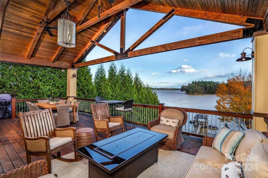 Lake James classic made anew. This bright and airy waterfront sanctuary is the family escape you've been waiting for. First note the premier view overlooking protected state park land, South Mountains, and sweeping Lake James water. This thoughtful home design incorporates the view from the front door all the way to the extensive back deck. Rustic touches like beamed and vaulted ceilings, wormy chestnut built-ins, and a charming fireplace to gather around can be seen along the way. The ample, well-appointed kitchen and primary bedroom suite on the main level make for easy, one level living. The den, two bedrooms, and a rec room that accommodates more sleepers below make it easy to include your friends and family. Even on the lower level, the covered and private back deck makes you feel like you can hang your feet in the water. There's just a short, easy walk down to your covered dock and boat lift from there. The terraced yard and waterfront patio allow for more outdoor living spaces.