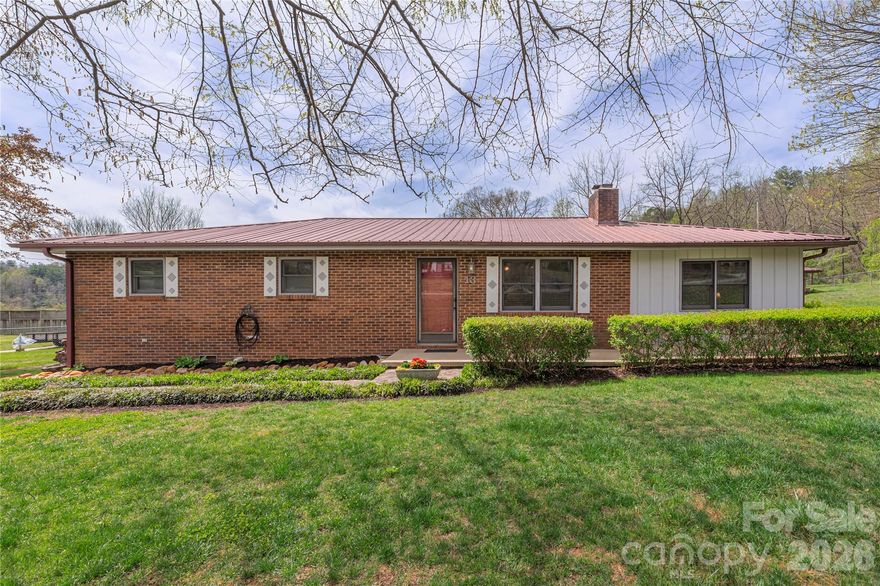 Nestled in the heart of Mills River, this solid brick classic offers the perfect blend of timeless charm and thoughtful modern updates. From the moment you arrive, you can feel the care and pride poured into every detail of this beautifully maintained home.

Inside, you’ll find gorgeous wood floors flowing throughout the living areas, hallways, and bedrooms, creating a warm and cohesive feel. The spacious den is the perfect place to unwind, featuring an oversized layout and a cozy wood-burning brick fireplace & bar area. Living room is also home to the brick fireplace with gas logs.

The kitchen is both functional and elevated, complete with a Dacor gas range and newer stainless steel appliances - ideal for everyday living or entertaining. Extensive custom cabinets with large pantry. Behind the scenes, major system upgrades provide peace of mind, including a new electrical 200 amp panel, all-new plumbing, a tankless water heater, and a water softener system.  Not to mention the furnace in 2022 and the A/C in 2023.

Set on nearly half an acre, the outdoor space is just as impressive. The fully fenced yard offers privacy and room to enjoy, with a beautifully redone back deck featuring Brazilian hardwood, a charming pergola, and a spacious screened-in porch & even a sitting area with fire pit.  The primary bedroom offers direct access to this inviting outdoor retreat.

Additional features include a private well within a shared well community, a durable and low-maintenance metal roof, an oversized double garage with workshop space, a carport, and an extra storage shed.

This is a home where quality, comfort, and care truly shine—ready for its next chapter.