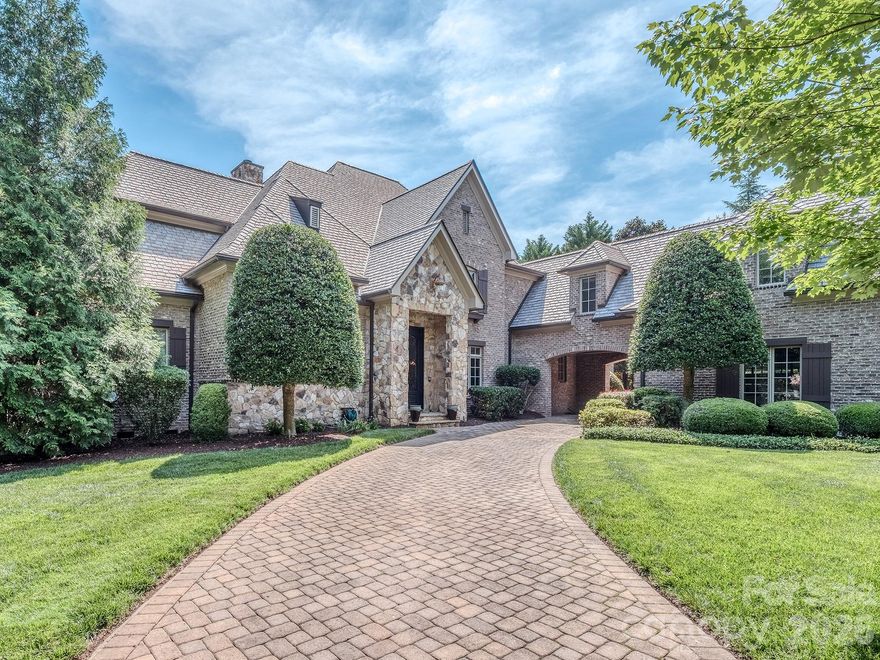 Welcome to luxury living in the prestigious, gated enclave of The Club at Longview. This magnificent brick and stone estate spans over 6,000 square feet of meticulously designed living space on a deeply private lot. Inside, the main level features a grand living room anchored by a floor-to-ceiling stone fireplace, custom built-ins, and an elegant iron chandelier. The chef's kitchen serves as the heart of the home, boasting premium granite countertops, custom wood cabinetry, an integrated stone-hood cooktop, a walk-in pantry, and a massive wrap-around breakfast bar perfect for hosting.

The main-level primary retreat features deep tray ceilings, a ceiling fan, and direct access through French doors to the private outdoor living spaces. Ascend the sweeping staircase to discover your dedicated entertainment zones, including an immersive media room and a massive upper-level bonus room. Transition seamlessly from the interior living spaces out to your private backyard oasis, which includes a covered rear porch overlooking the trees and a stunning outdoor fireplace. Enjoy world-class community amenities including a premier golf course, tennis complexes, fitness facilities, and clubhouse dining. A golf membership is required with the purchase of this home.