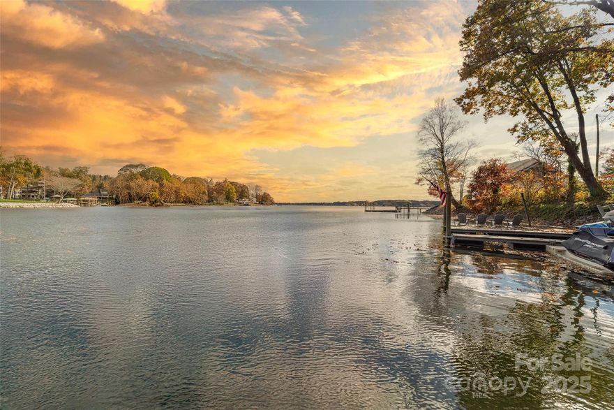 Lake Norman Luxury Waterfront Home • No HOA • .61 Acre Lot. For the most complete view of this beautiful lakefront property, be sure to watch the full video tour.

Experience custom designed lakefront living in this thoughtfully designed luxury home that blends sophistication, comfort, and captivating long-range waterfront views from a perfect swimming cove. Every detail has been curated to deliver the perfect balance of modern elegance and relaxed lake living.

Spanning three spacious levels, this residence offers generous spaces to entertain, unwind, and enjoy life on the lake.

The primary suite is a serene retreat with a spa-inspired bath, soaking tub, and custom walk-in closet with built-in laundry and amazing lake views. The chef’s kitchen impresses with designer finishes, double Sub-Zero refrigerators and Wolf appliances, including a six burner range, wall oven and microwave, complemented by a butlers pantry and a walk-in pantry. The great room, anchored by an expansive brick fireplace with gas starter and built-in wood storage, flows seamlessly to the screened porch and deck for waterside dining and breathtaking views. A powder room and breakfast area complete this level. All 10 wall mounted TV’s convey with the home present at showings, including two Samsung Frame TVs that blend artfully into the décor.

Upstairs are three spacious bedrooms and three full baths, including a second suite, plus a fabulous media room featuring built-in twin-over-queen bunks, ideal for guests. A flex room/office and second laundry room provide comfort and versatility for family and visitors alike.

Designed for entertaining and everyday enjoyment, the walkout basement features a built-in bar area with a sink, dishwasher, and a Sub-Zero wine refrigerator. A pass through serving window opens up to an outdoor counter, dining space, and grilling area with built-in propane hookup for convenient outdoor cooking and entertaining. 

Additional highlights include billiards table area (table can remain), workout space, office, second large brick fireplace with gas starter, as well as a walk-in closet, ample storage, and full bath.

Enjoy long-range lake views from the beautifully landscaped .61-acre lot, featuring a fire pit, irrigation system, and covered dock (built 2019) with a 7,000 lb cable pontoon (or convert to boat) lift, floating jet ski dock, and Generac generator.

The front entry is enhanced by a gas lantern, adding charm and welcoming ambiance. The EV-ready garage with 220-amp plug, whole-house central vac system, storage closets, and greenhouse add convenience and functionality.
This move-in-ready luxury home is a true standout on Lake Norman, offering an unmatched setting for Everyday Lake Living, all with no HOA dues.