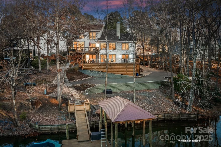 Discover your dream WATERFRONT contemporary home in the heart of Tega Cay! This stunning home offers 5 bedrooms and 4 full baths and 2 ½ baths. There are two 2-car garages and a HUGE driveway and 4 dedicated parking spaces in front. The 2 story Great Room features a wood burning fireplace overlooking the view of the lake. There is a screened in porch off the Kitchen/Dining Room. Primary Bedroom on Main level has an ensuite and 2 walk in closets. Lower level has 2 Bedrooms plus Den & a kitchenette. Low maintenance floating dock with covered boat storage. Peaceful lot located on a protected deep water cove just off the main channel on Torrence Creek with 147' of shoreline. This home could work for Multi-Generational living or rental. Just over the border from Charlotte, NC. Top ranked Fort Mill Schools. Enjoy the recreational lake city of Tega Cay. Waterfront parks, boat ramps, beaches, sport courts, pickleball, tennis, Tega Cay Golf Club, Tega Cay Beach & Swim Club, walking trails, & more.  New Roof, windows, doors, paint, flooring, decks were expanded with a screen porch addition in 2020.  New covered boat dock in 2022.  Too many renovations and upgrades to list!  This is a MUST SEE!